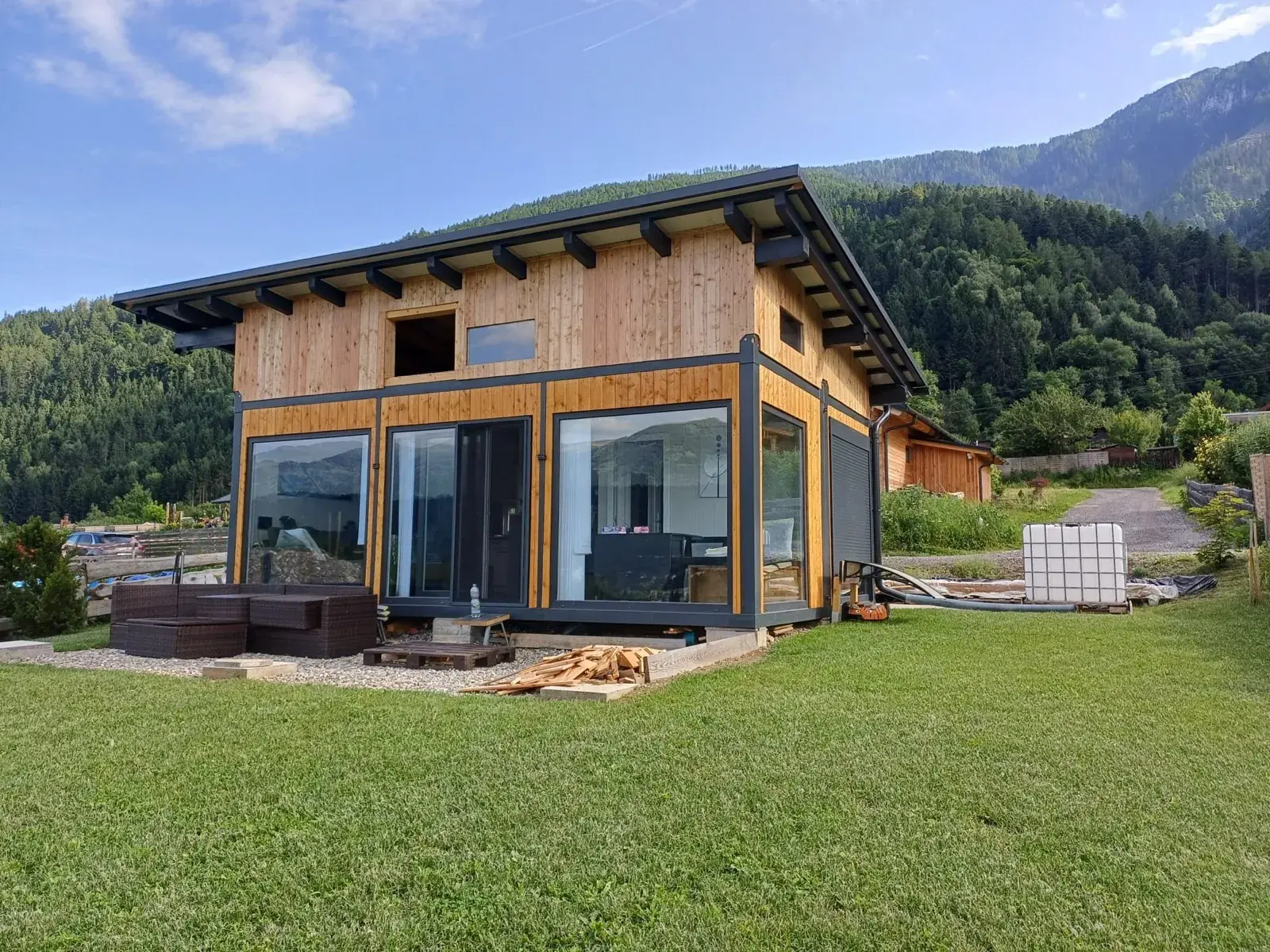 Casa in container con rivestimento in legno e vetrate d'angolo tra le montagne