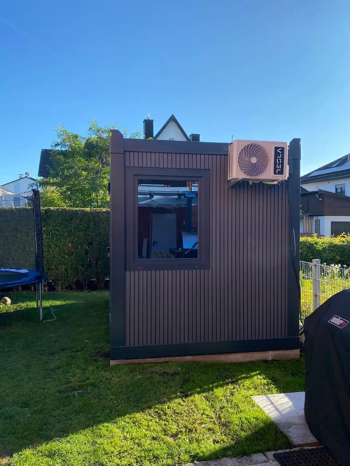 Container da giardino con decoro legno accanto al prato