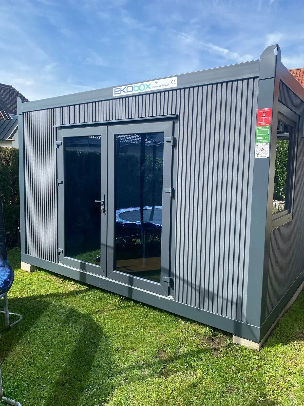 Container da giardino con rivestimento grigio e porta finestra