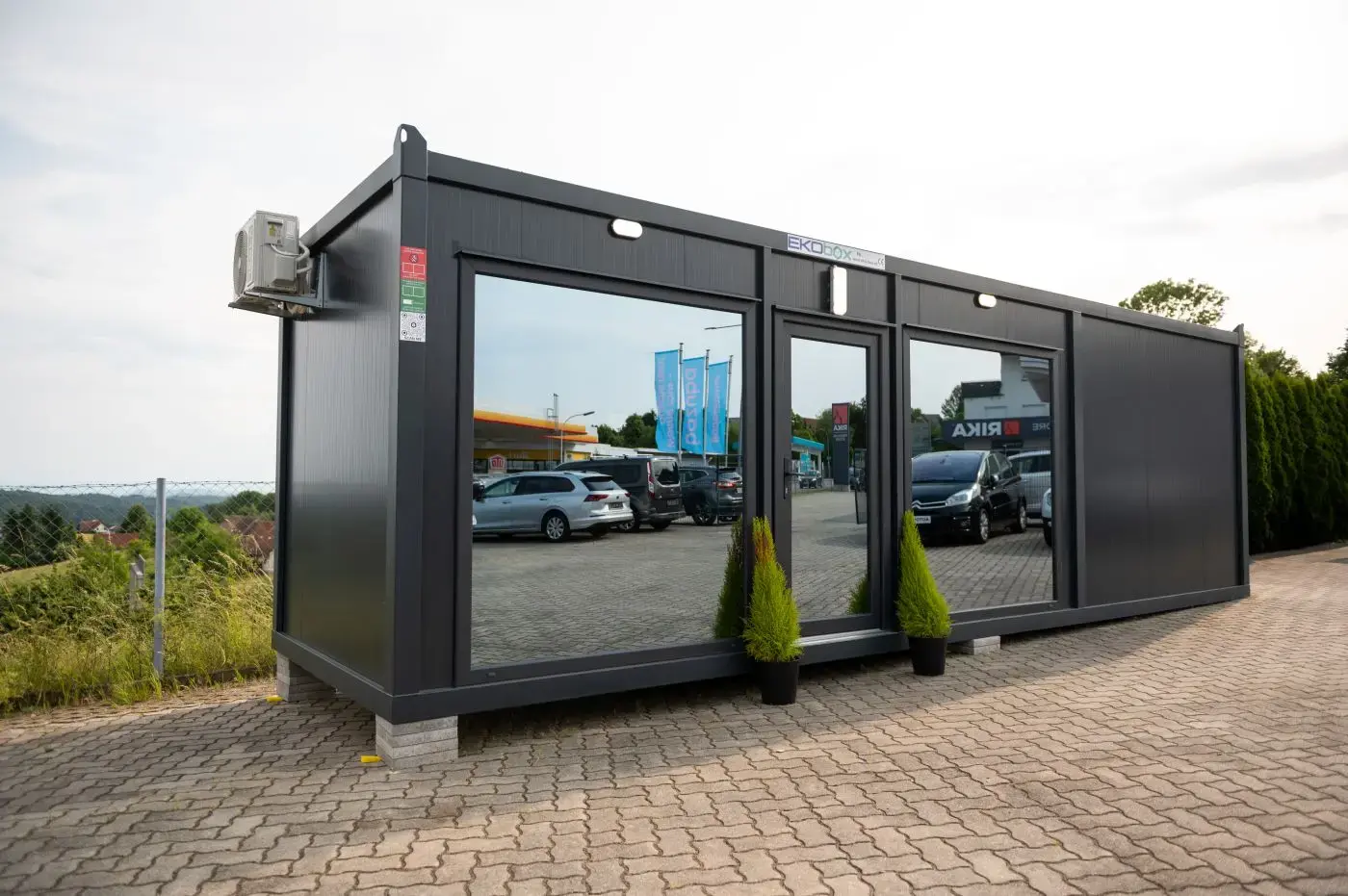 Container ufficio vetrato in un parcheggio
