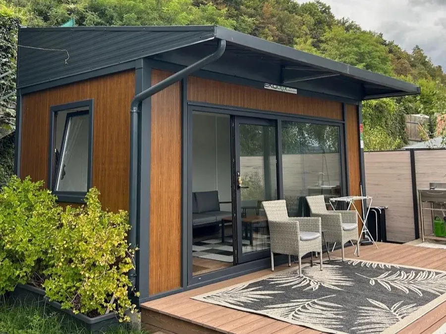 Container con tettoia aggiuntiva e rivestimento in legno