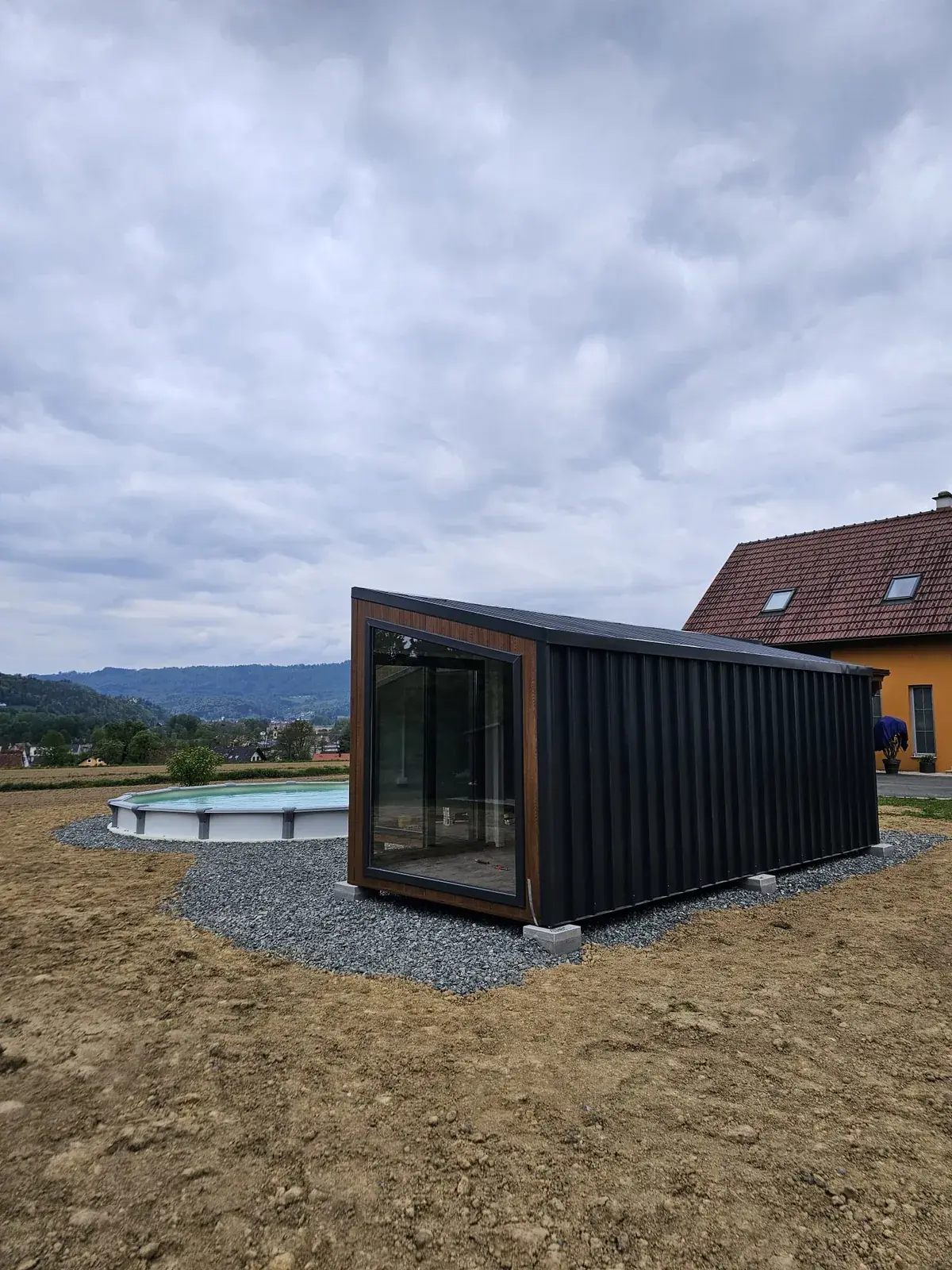 Tiny house con rivestimento scuro sulla base preparata