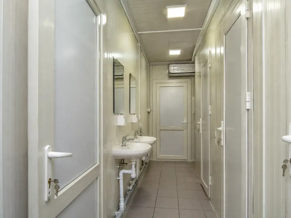 Interno di un container sanitario standard con WC e lavabi