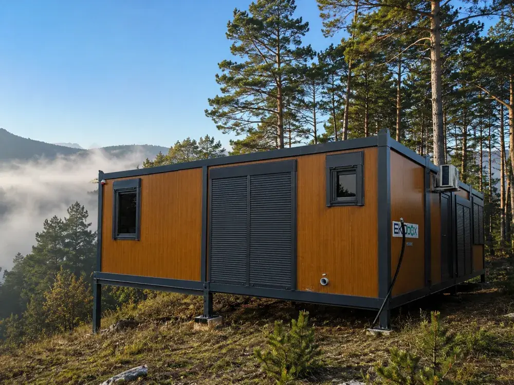 Tiny house container in una radura nel bosco